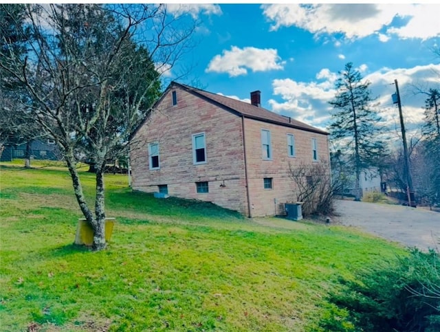 view of property exterior featuring a lawn and central air condition unit