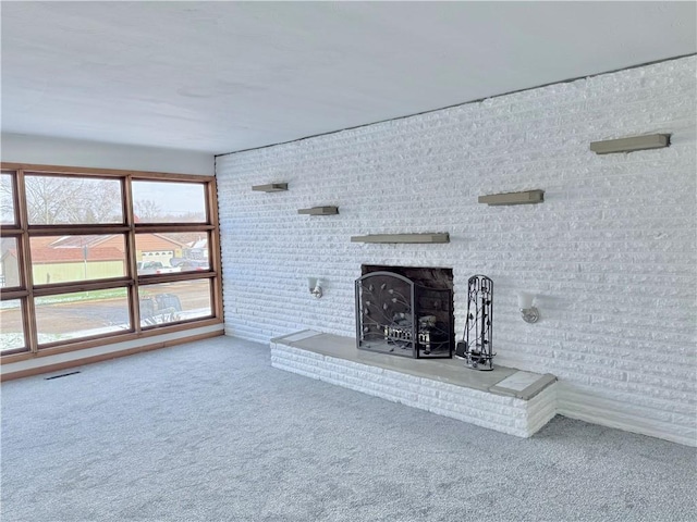 unfurnished living room with carpet floors and a brick fireplace