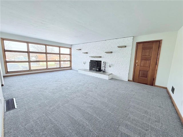 unfurnished living room featuring carpet floors and brick wall