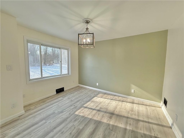 unfurnished dining area featuring light wood-type flooring and an inviting chandelier