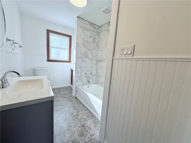 full bathroom featuring tile patterned floors, vanity, toilet, and tiled shower / bath combo