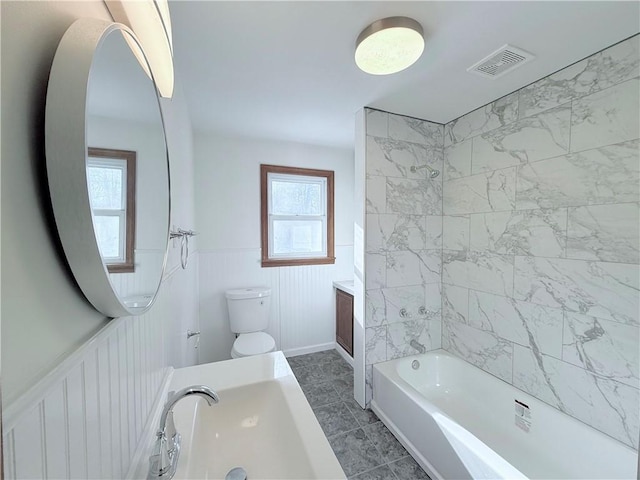 full bathroom with tiled shower / bath, tile patterned flooring, vanity, and toilet