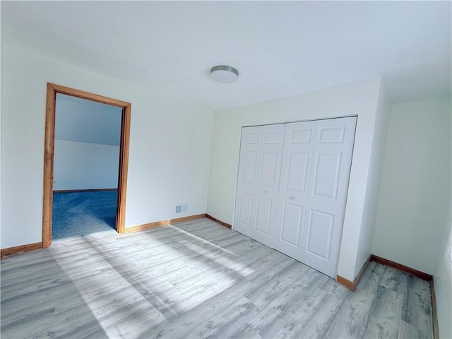 unfurnished bedroom featuring a closet and light hardwood / wood-style floors