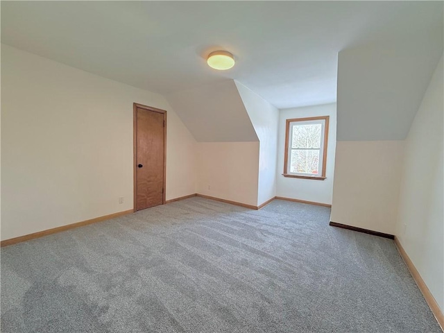 bonus room with light carpet and lofted ceiling