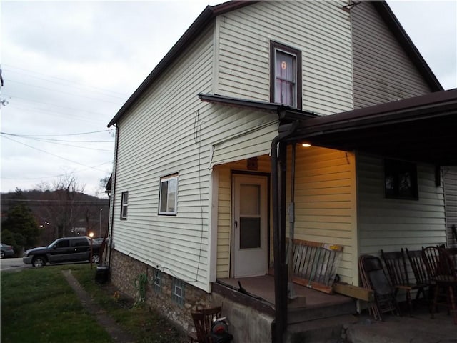 view of side of property featuring covered porch