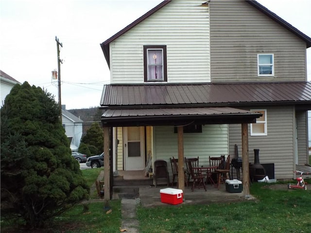 back of property with a patio area and a lawn