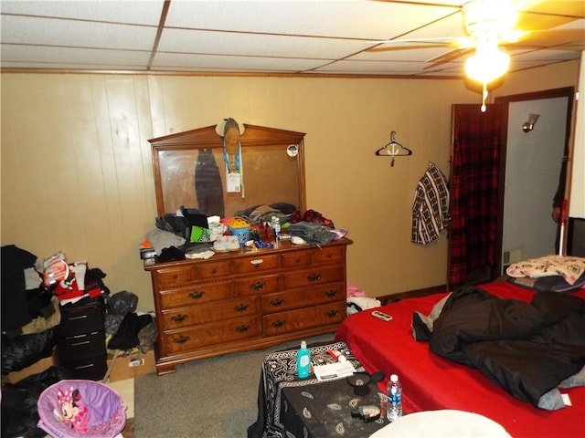 carpeted bedroom with a paneled ceiling and ceiling fan