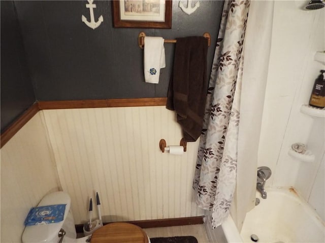 bathroom featuring shower / bath combo and wooden walls