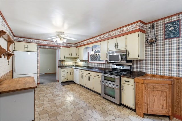 kitchen with ceiling fan, decorative backsplash, appliances with stainless steel finishes, and cream cabinets