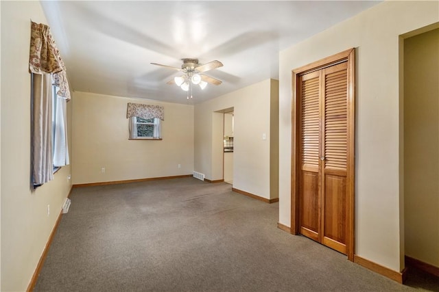 carpeted spare room featuring ceiling fan