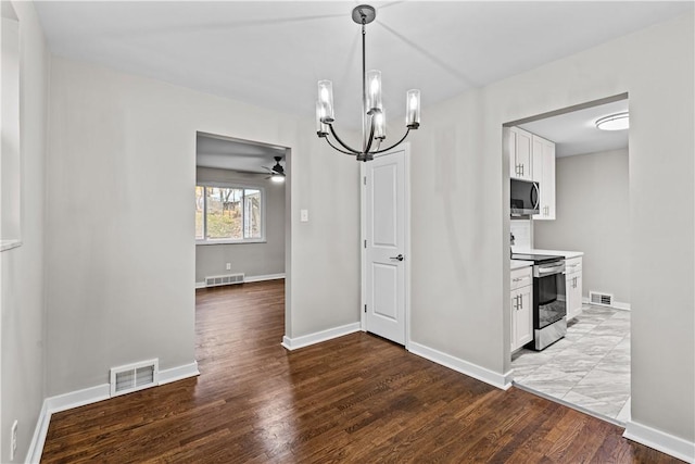 kitchen with white cabinets, ceiling fan with notable chandelier, hanging light fixtures, appliances with stainless steel finishes, and light hardwood / wood-style floors