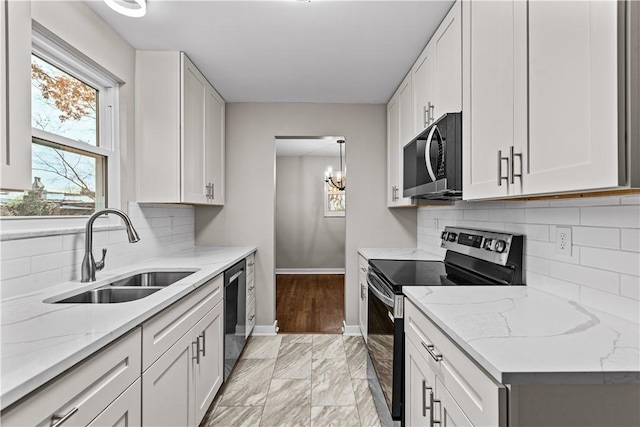 kitchen featuring appliances with stainless steel finishes, tasteful backsplash, light stone counters, sink, and white cabinets