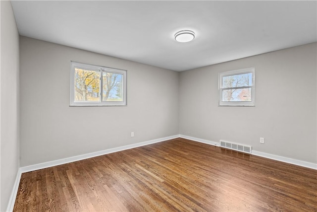 unfurnished room with hardwood / wood-style floors and a healthy amount of sunlight