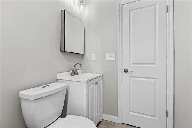 bathroom featuring hardwood / wood-style flooring, vanity, and toilet