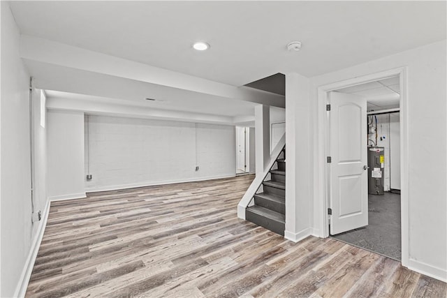 basement with hardwood / wood-style floors and electric water heater