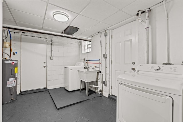 laundry room featuring washing machine and dryer, electric water heater, and sink