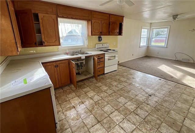 kitchen featuring backsplash, white range with electric cooktop, ceiling fan, and sink