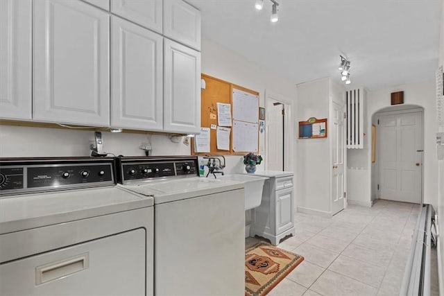 washroom with washer and clothes dryer, light tile patterned flooring, and cabinets