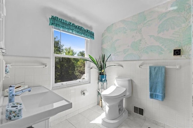 bathroom with tile patterned floors, sink, tile walls, and toilet