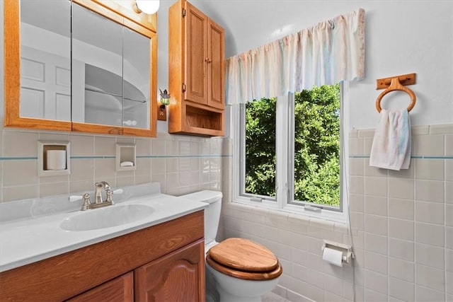 bathroom with vanity, tile walls, and toilet