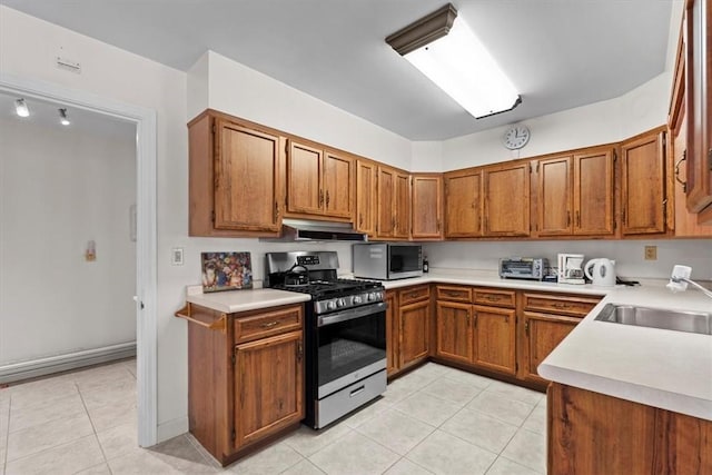 kitchen with light tile patterned flooring, sink, and appliances with stainless steel finishes