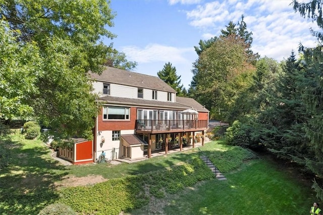 rear view of house with a lawn and a wooden deck