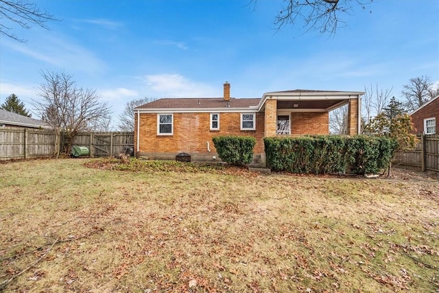 back of house featuring a lawn