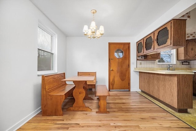 dining space with light wood-type flooring and a notable chandelier