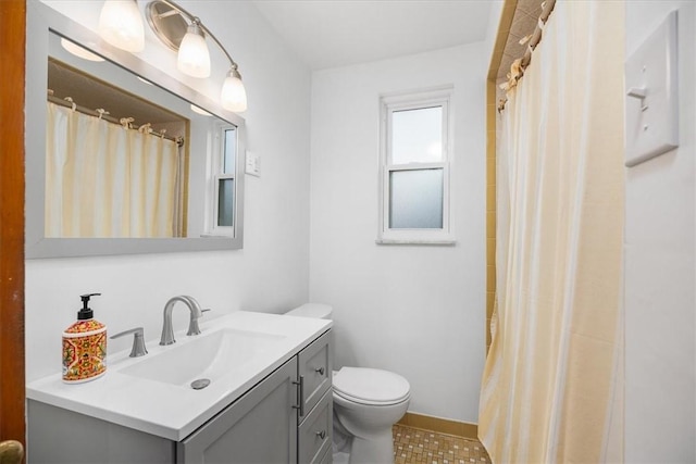 bathroom featuring tile patterned flooring, vanity, toilet, and walk in shower