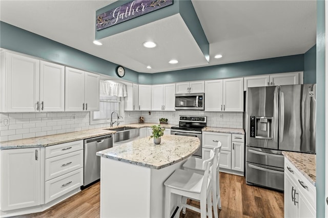 kitchen featuring white cabinets, a kitchen island, stainless steel appliances, and hardwood / wood-style flooring