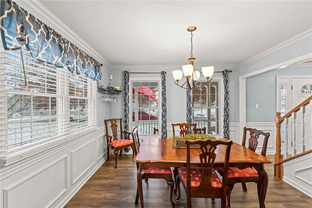 dining area with dark hardwood / wood-style flooring, ornamental molding, and a notable chandelier