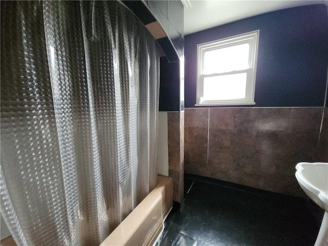 bathroom featuring tile walls and shower / tub combo