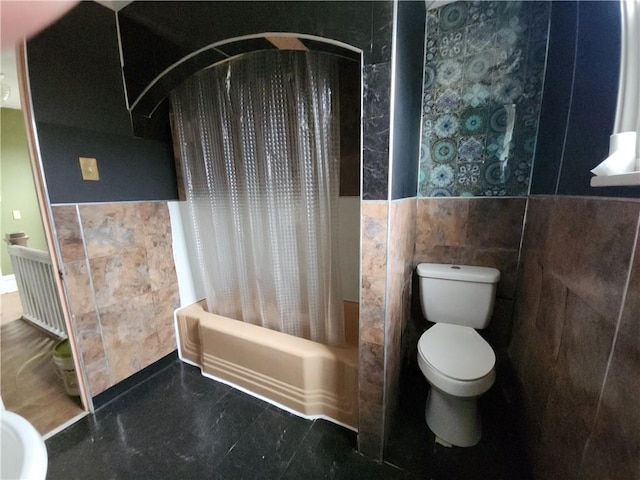 bathroom featuring radiator, shower / bath combo with shower curtain, tile walls, and toilet