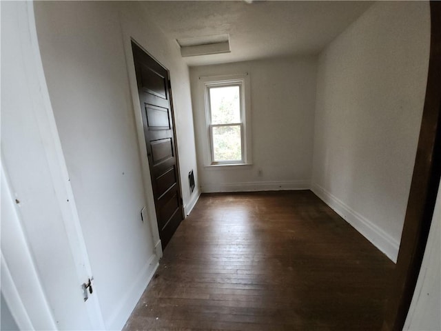 unfurnished room with dark wood-type flooring