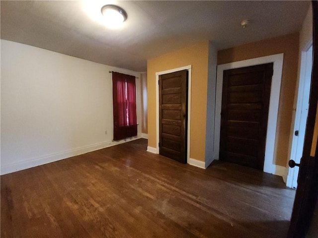 unfurnished bedroom featuring dark hardwood / wood-style floors and a closet