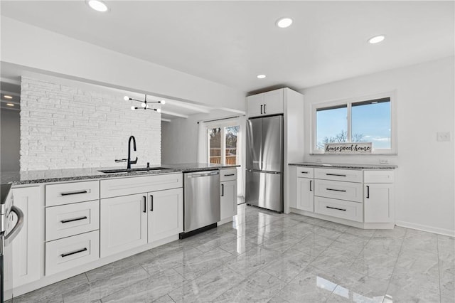 kitchen featuring white cabinets, dark stone countertops, sink, and appliances with stainless steel finishes