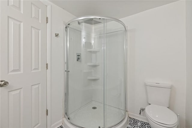 bathroom featuring tile patterned flooring, toilet, and walk in shower