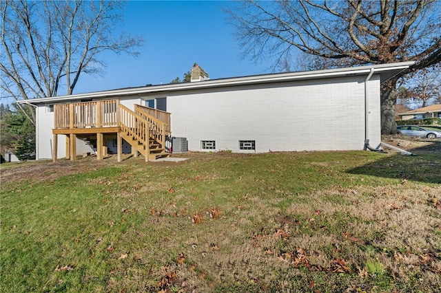 rear view of house featuring a lawn, central AC unit, and a deck