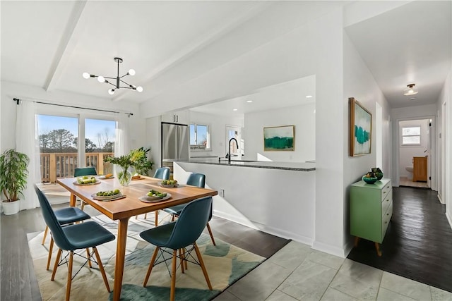 dining space with a notable chandelier, plenty of natural light, and light hardwood / wood-style flooring