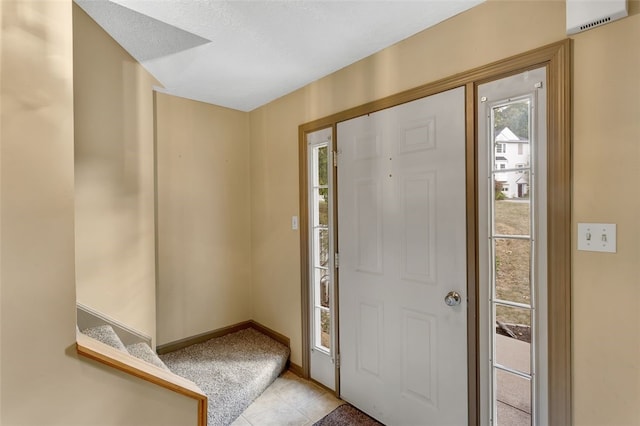 entrance foyer featuring light tile patterned floors and a textured ceiling