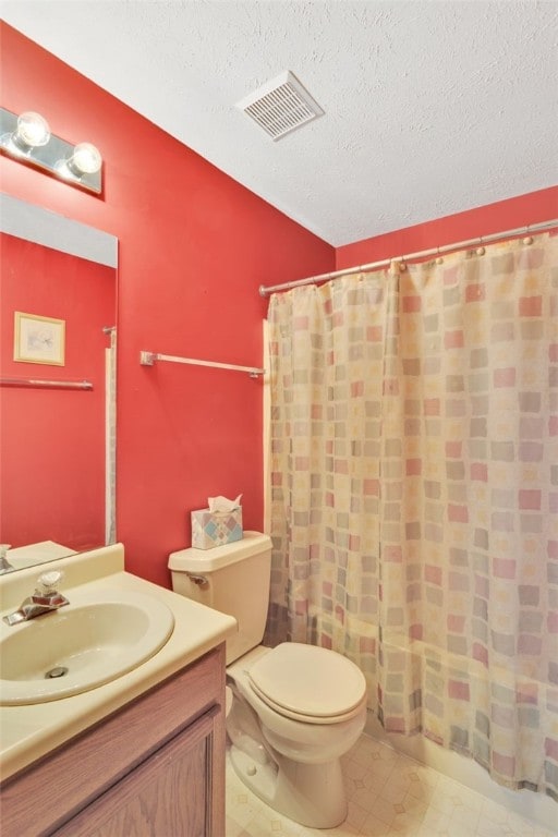 bathroom with vanity, a textured ceiling, and toilet