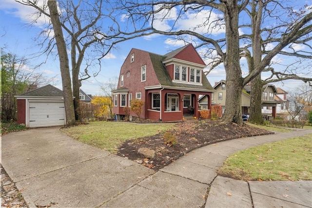 view of front of property with a front lawn, covered porch, an outdoor structure, and a garage