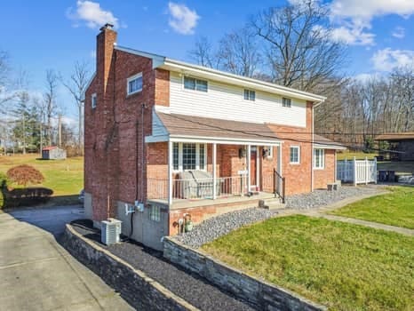 view of front of house featuring covered porch and a front lawn