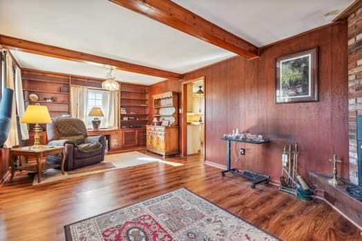 interior space with hardwood / wood-style floors, beamed ceiling, and wooden walls