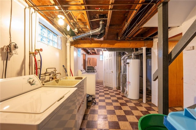 basement with washing machine and clothes dryer, sink, and water heater