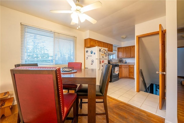 dining space with light hardwood / wood-style floors and ceiling fan