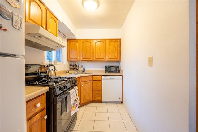 kitchen featuring black appliances, light tile patterned floors, and sink