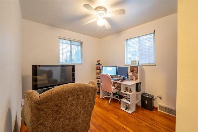 office with a healthy amount of sunlight, ceiling fan, and wood-type flooring