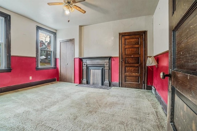 unfurnished living room featuring carpet flooring, ceiling fan, and a baseboard radiator