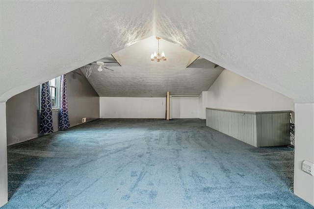 additional living space with vaulted ceiling, carpet, a chandelier, and a textured ceiling